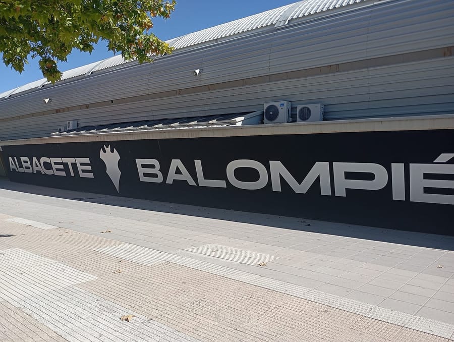 Fachada del estadio Carlos Belmonte con el rótulo «Albacete Balompié» y el escudo del club sobre fondo negro, bajo un cielo despejado