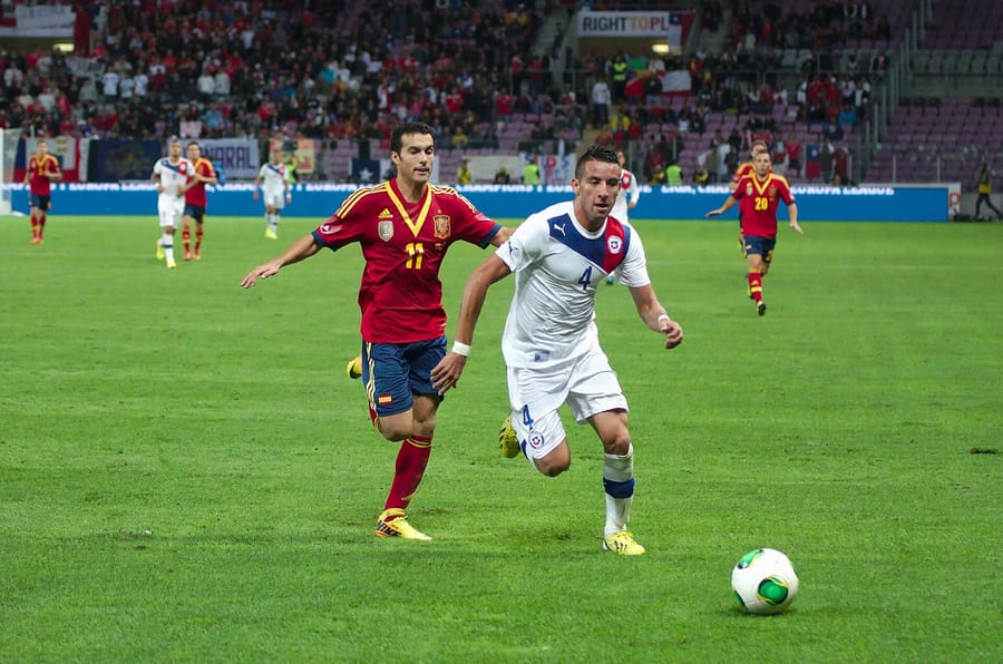 Pedro Rodríguez, con el 11 de España, persigue al chileno Mauricio Isla en un amistoso disputado en Ginebra en septiembre de 2013